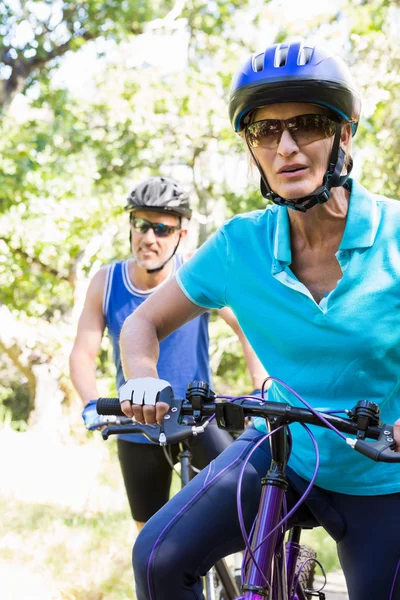 Casal maduro com óculos de sol andar de bicicleta — Fotografia de Stock