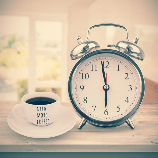 Cup and alarm clock on desk — Stock Photo, Image
