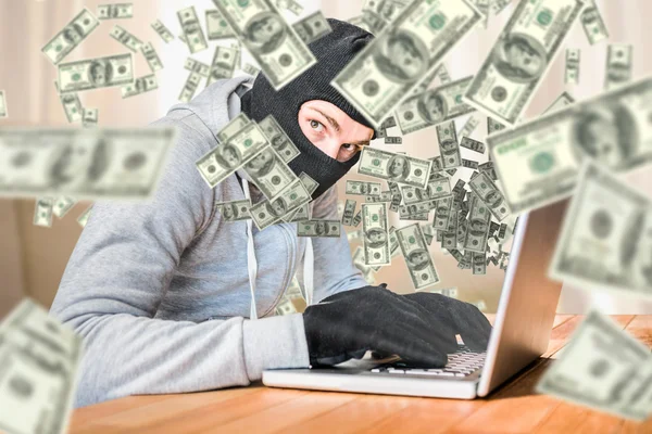 Thief with hood typing on laptop — Stock Photo, Image