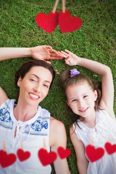 Mother and daughter lying on grass — Stock Photo, Image