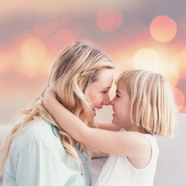 mother and daughter rubbing noses on sofa clipart