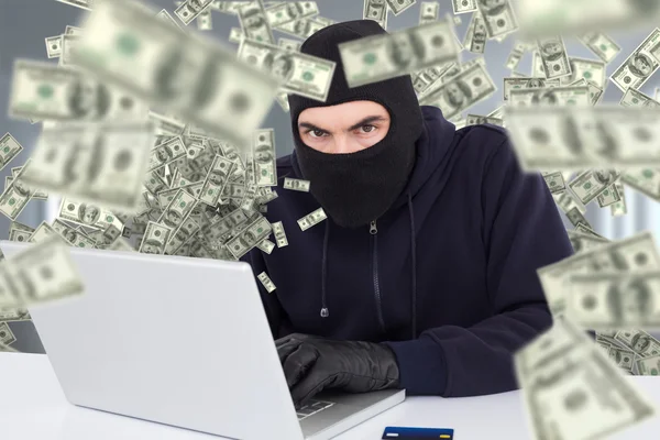 Хакер в балаклаве взлома ноутбука — стоковое фото