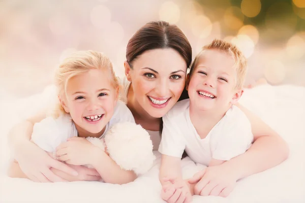 Mère et enfants couchés sur un lit — Photo