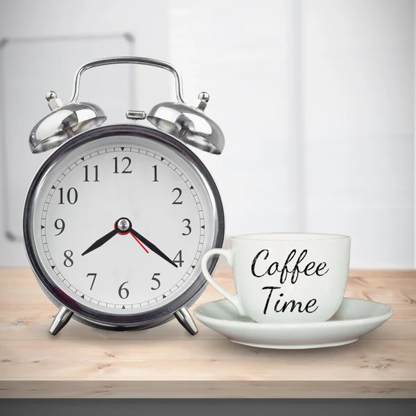 Xícara de café e despertador na mesa — Fotografia de Stock