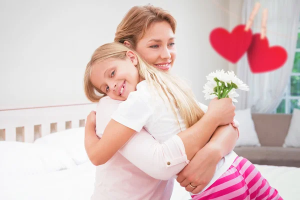 Moeder en dochter knuffelen met bloemen — Stockfoto