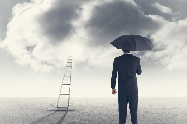 Empresário abrigamento com guarda-chuva — Fotografia de Stock