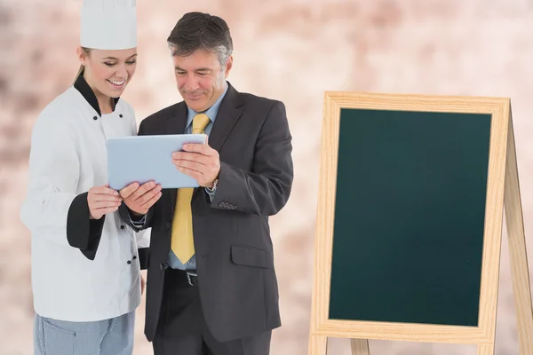 Cook showing a tablet to a businessman — Stock Photo, Image