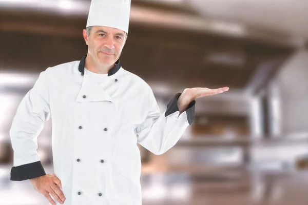 Mature chef displaying invisible product — Stock Photo, Image