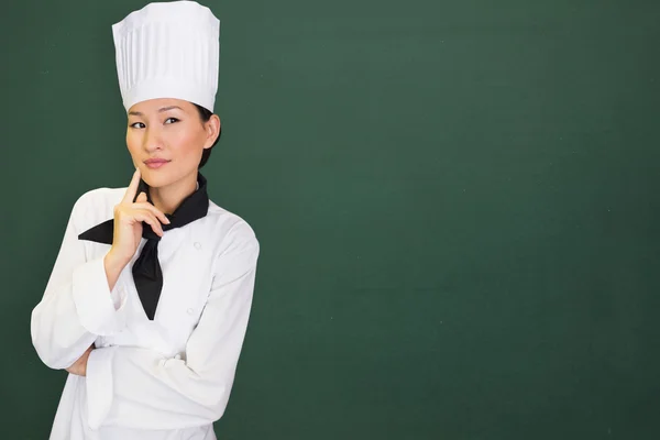 Pensativo cocinero femenino en la cocina Imagen de stock