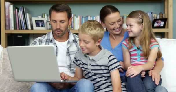 Famille en utilisant un ordinateur portable assis sur le canapé — Video