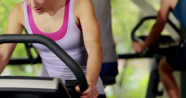 Fit mujer haciendo bicicleta estática — Vídeo de stock