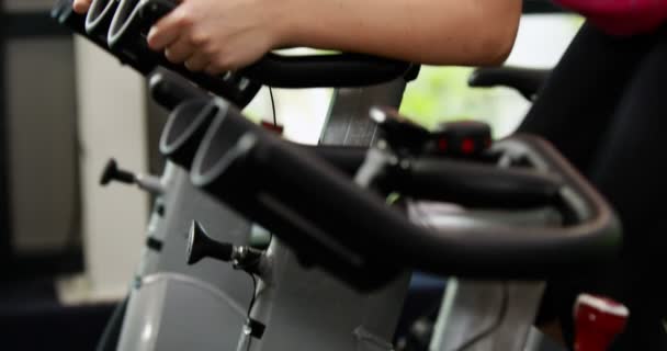 Ajuste mujer usando bicicleta estática — Vídeos de Stock