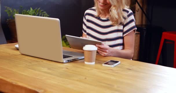 Vrouw die koffie drinkt en tablet gebruikt — Stockvideo