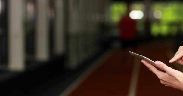 Entrenador femenino comprobando los resultados en la tableta — Vídeo de stock