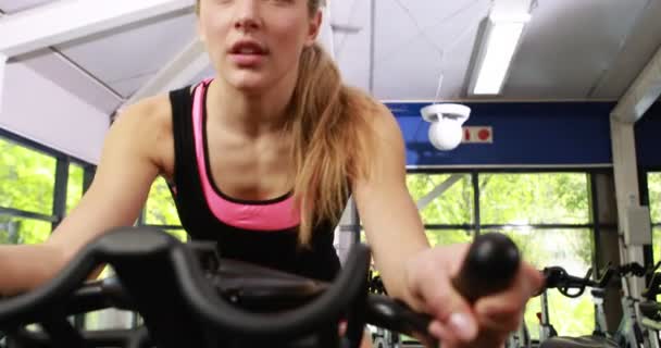 Ajuste mujer usando bicicleta estática — Vídeos de Stock