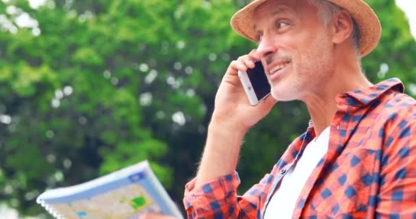 Smiling man with map calling — Stock Video