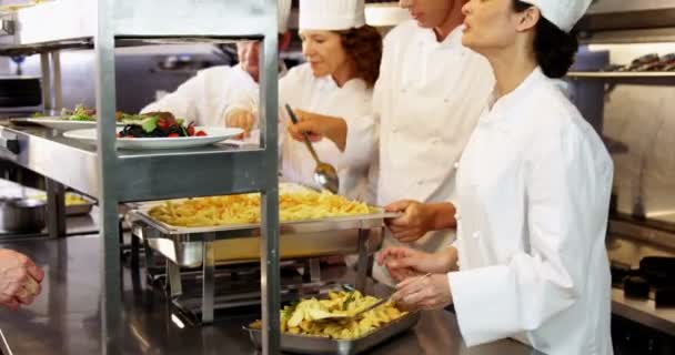 Grupo de chefs dando platos en línea de pedido — Vídeo de stock