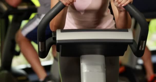 Fitte Frau auf dem Heimtrainer lächelt in die Kamera — Stockvideo