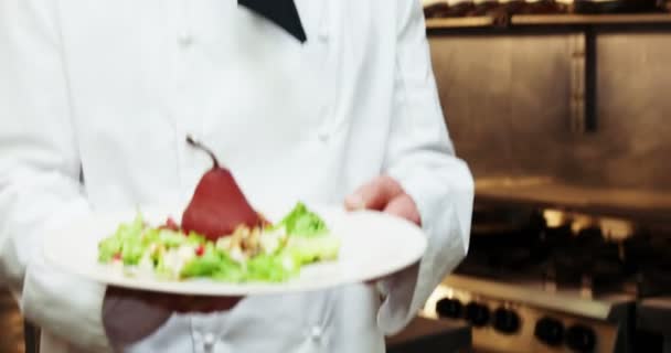 Handsome chef holding a plate with a poach pear — Stock Video