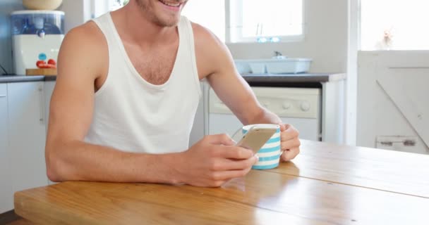 Homme prenant du café et utilisant un smartphone — Video