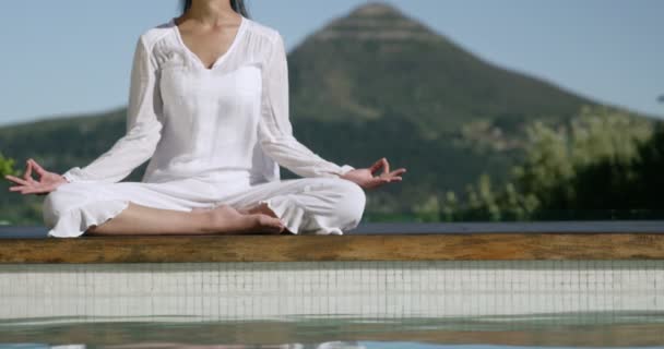 Rustige vrouw doen yoga bij het zwembad — Stockvideo