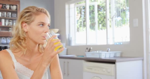 Femme blonde boire du jus d'orange — Video