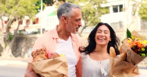 Pareja sonriente con bolsas de comestibles — Vídeo de stock