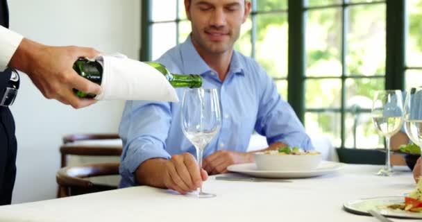 Handsome waiter pouring wine in a client glass — Stock Video