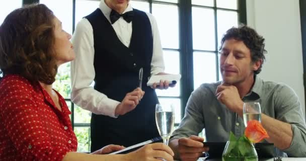 Χαριτωμένο ζευγάρι παραγγελία μορφή το μενού για να την σερβιτόρα — Αρχείο Βίντεο
