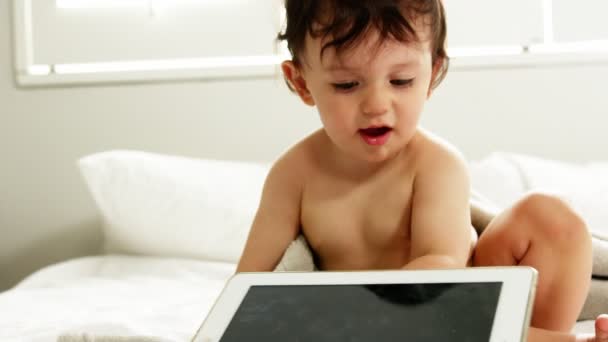 Menino está olhando seu tablet — Vídeo de Stock