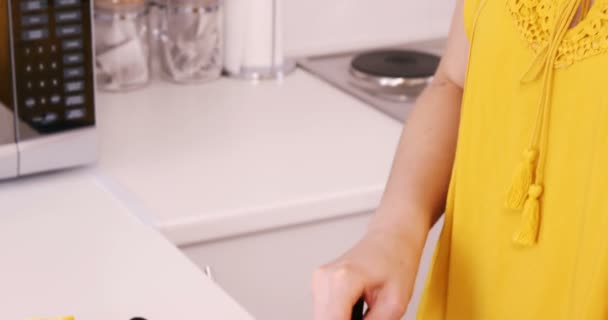 Улыбающаяся женщина режет овощи — стоковое видео