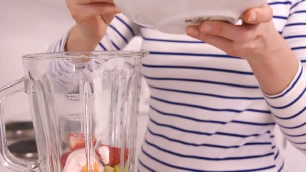 Mujer rubia preparando un batido — Vídeos de Stock