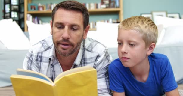 Padre le está leyendo un libro a su hijo — Vídeos de Stock