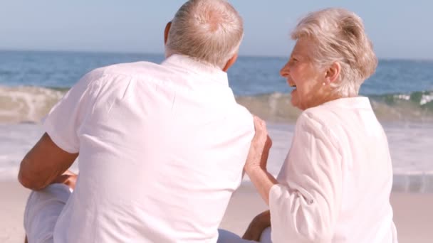 Pareja madura sentada en la playa — Vídeo de stock