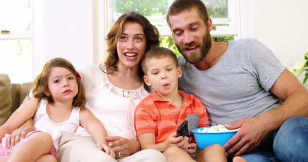 Familie met pop-maïs op een bank — Stockvideo