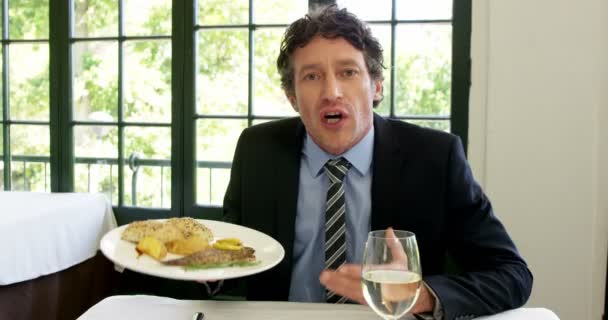 Разочарованный мужчина держит тарелку с едой в ресторане — стоковое видео
