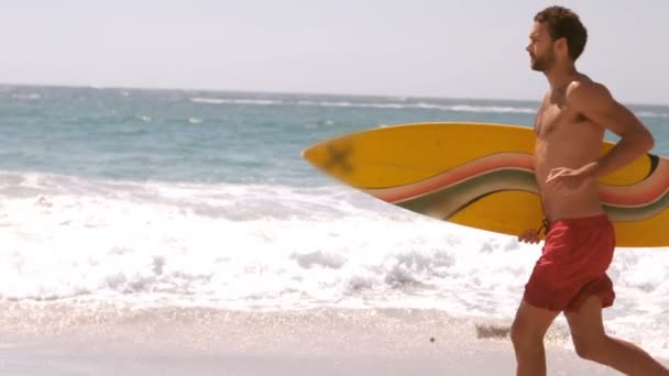 남자는 그의 서핑 보드와 함께 실행 — 비디오