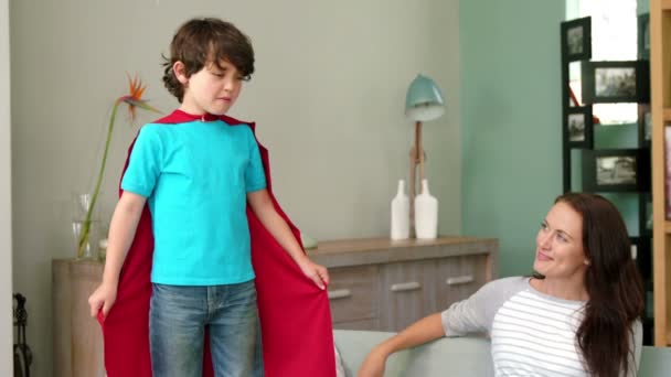 Un niño fingiendo ser un superhéroe mientras su madre lo cuida — Vídeos de Stock