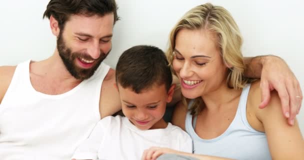 Família sorrindo e sentado em uma cama — Vídeo de Stock