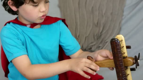 Kleine jongen spelen met een speelgoed vliegtuig — Stockvideo
