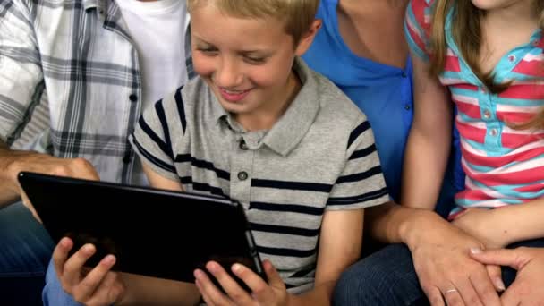 Rodina sedí na pohovce dívá tablet — Stock video