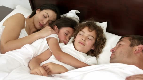 Семья спит в одной постели — стоковое видео
