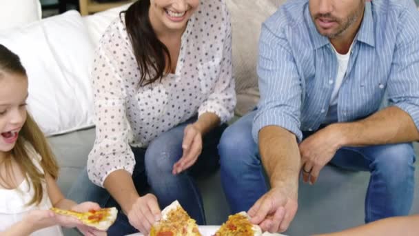 Familie isst gemeinsam Pizza auf dem Sofa — Stockvideo