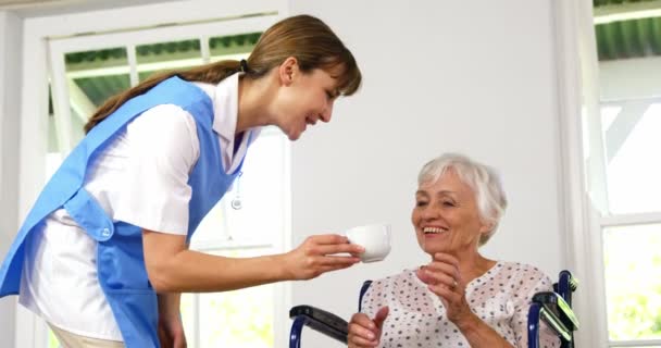 Krankenschwester gibt einer reifen Frau eine Tasse — Stockvideo