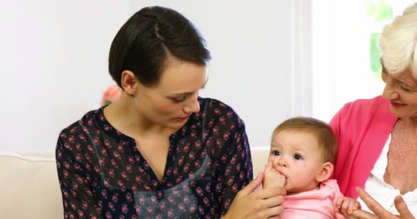 Flickorna i familjen sitter i soffan med barnet — Stockvideo