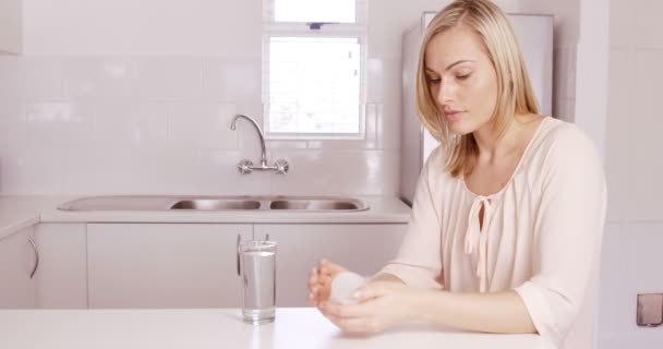 Mujer tomando una pastilla en la cocina — Vídeos de Stock