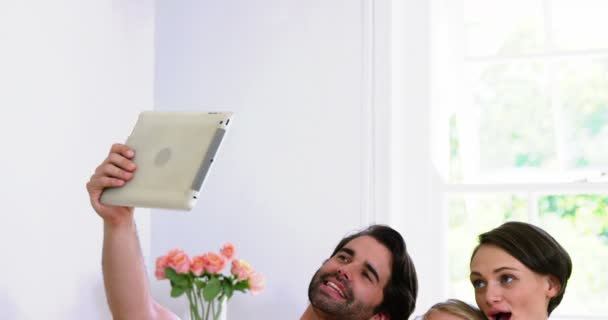 Linda familia sonriendo y tomando una foto con una tableta — Vídeo de stock