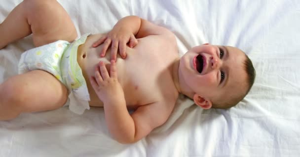 Bonito bebê rindo e mentindo — Vídeo de Stock
