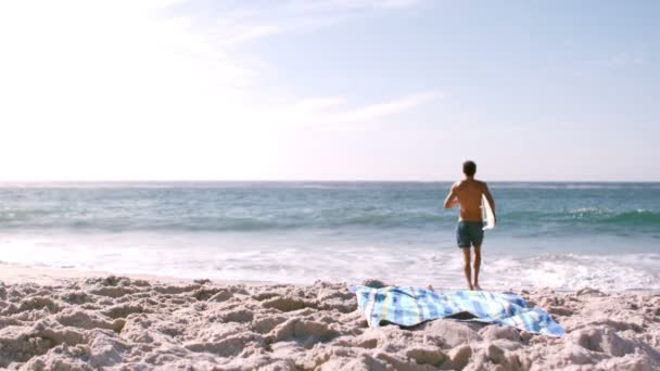 Homem está correndo com sua prancha de surf — Vídeo de Stock