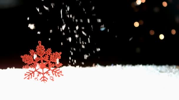 Nieva en un copo de nieve rojo — Vídeo de stock
